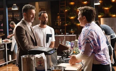 Judges engage with a contestant in a kitchen setting on a cooking competition show.