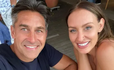 A smiling couple taking a selfie at an outdoor setting.