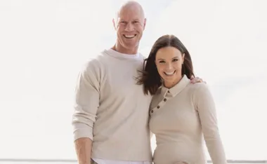 Couple smiling while enjoying a bright day outdoors.
