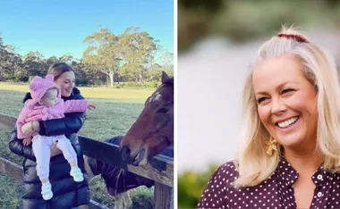 Mother and child in pink jacket by a horse, alongside a smiling woman with blonde hair in polka dot shirt outdoors.