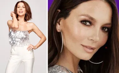 A woman poses confidently in a silver sequin top, with short brown hair and hoop earrings.