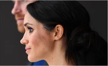 Profile of a woman with dark hair pulled back, looking attentive.