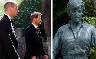 Two people in suits walking next to a statue of a woman in a garden setting.