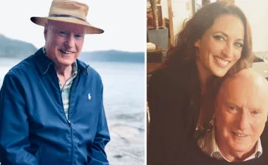 Man in a blue jacket by the sea; woman smiling with him indoors.