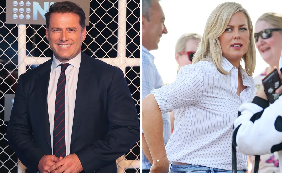 ```
Smiling man in suit beside a woman in a striped shirt outdoors.
```