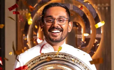 Winner of MasterChef 2021 joyfully holding a trophy, surrounded by colorful confetti.