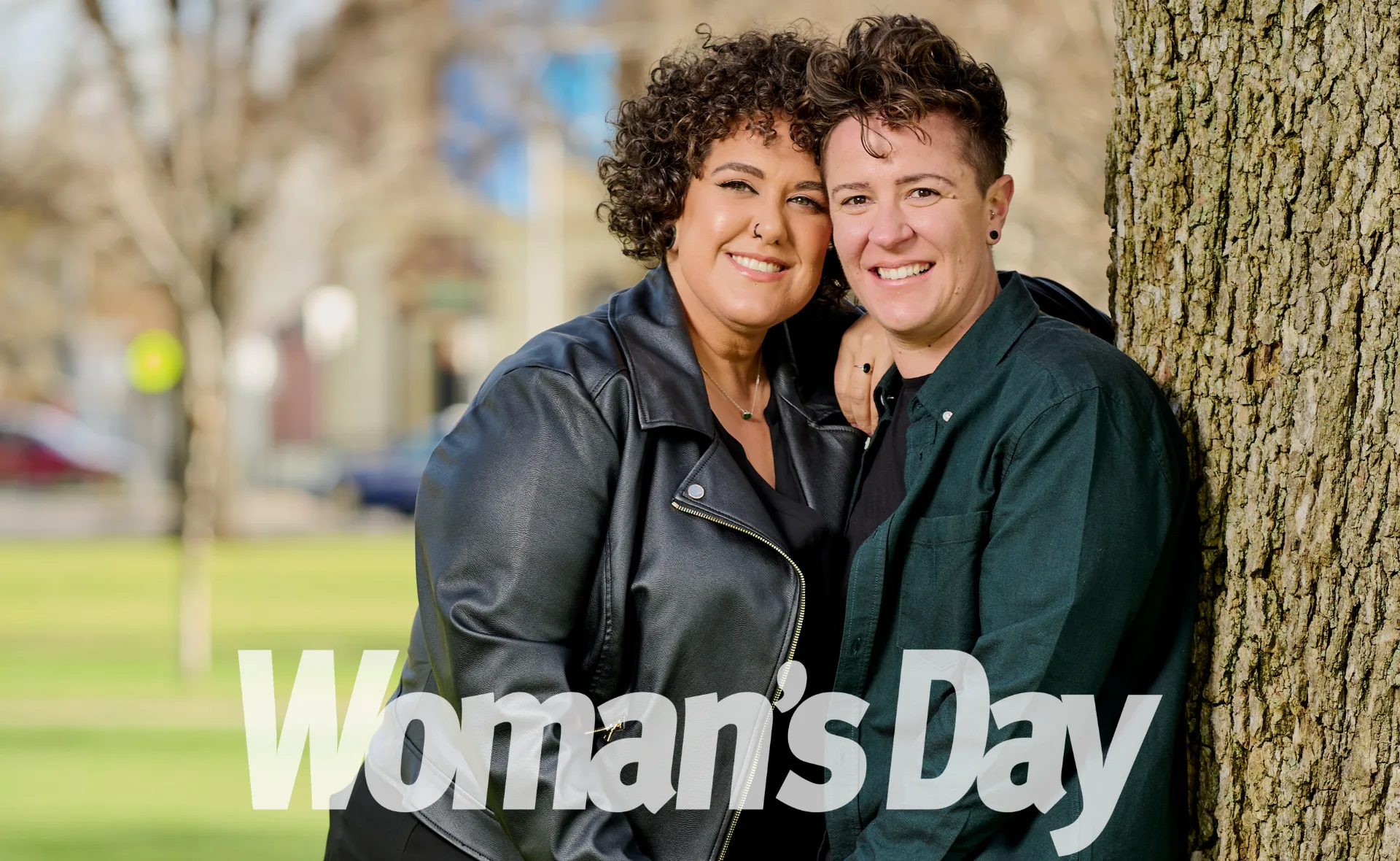 Two people smiling and embracing near a tree, with "Woman's Day" text overlay.