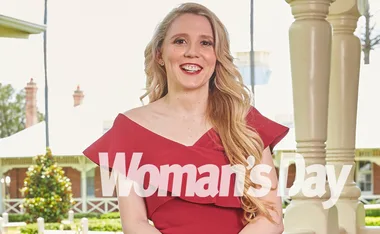 A woman in a red dress smiles outdoors, with "Woman's Day" magazine text overlaid.