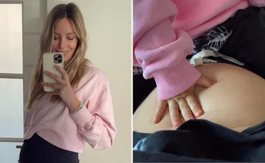 Pregnant woman in pink sweater taking a mirror selfie; close-up of child's hand on belly.