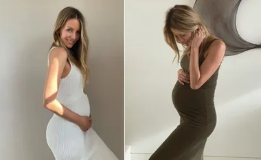 Pregnant woman in white and green dresses, posing with her hands on her belly, smiling and looking downward.