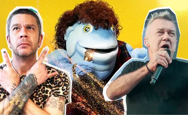 A blue puppet with curly hair sings into a microphone, flanked by two men, one crossing arms and one holding a mic.