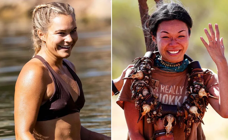 Two women smiling, one in a bikini by a lake, the other wearing tribal jewelry, outdoors in a sunny setting.