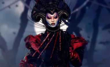Vampire character from The Masked Singer, with elaborate headpiece, fangs, dark makeup, and red-black costume.