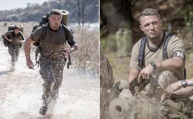 Man in military gear running through water and resting during outdoor training exercise.