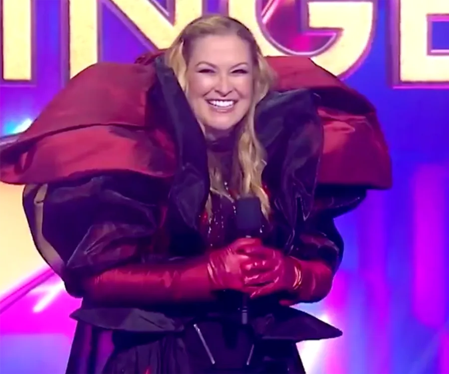Smiling performer in elaborate red and black costume on stage during The Masked Singer Australia 2021 finale.