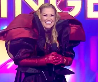 Smiling performer in elaborate red and black costume on stage during The Masked Singer Australia 2021 finale.