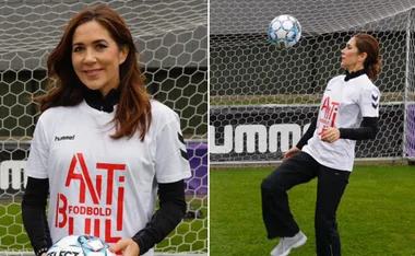 Princess wearing an "Anti Bullying" shirt, holding and juggling a soccer ball on a field.