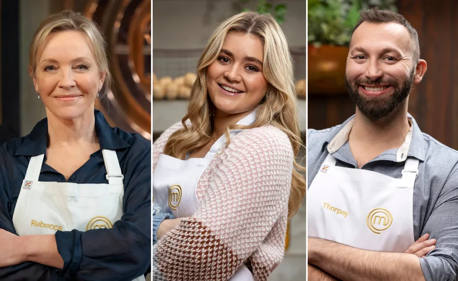 Three people in aprons smiling, likely contestants on a cooking show.