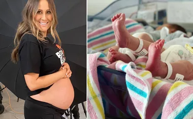 Pregnant woman smiling and twin newborns' feet wrapped in striped blankets.