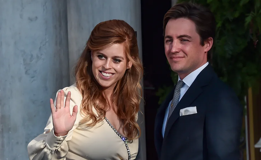 Princess Beatrice and Edoardo Mapelli Mozzi at an event, with Beatrice waving and both smiling.