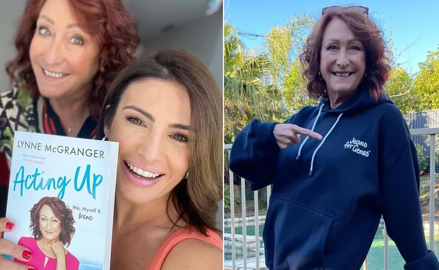 Two women smiling; one holding a book titled "Acting Up" by Lynne McGranger, the other points to "Jeans for Genes" hoodie.
