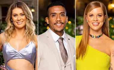 Three people from "The Bachelorette 2021" dressed formally, smiling at an event with blurred lights in the background.