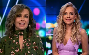 Two women in a studio setting, one in a floral dress, the other in a lavender top, with colorful blurred lights behind.