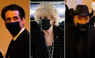 Three people in formal attire and black masks at a funeral event.