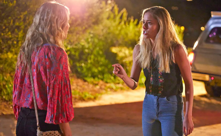 Two women arguing outside at night, one gesturing emphatically, in a scene from "Home and Away".