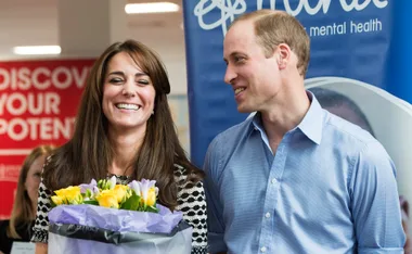 Man and woman smiling; woman holding bouquet at a mental health event.
