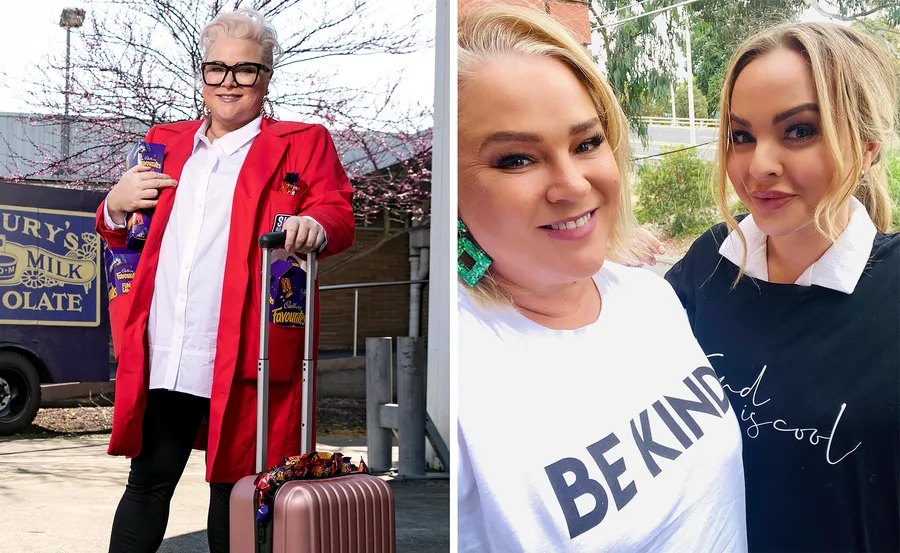 Two women smiling; first with short blonde hair in a red coat holding chocolates, the second in a "Be Kind" T-shirt.