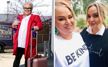 Two women smiling; first with short blonde hair in a red coat holding chocolates, the second in a "Be Kind" T-shirt.