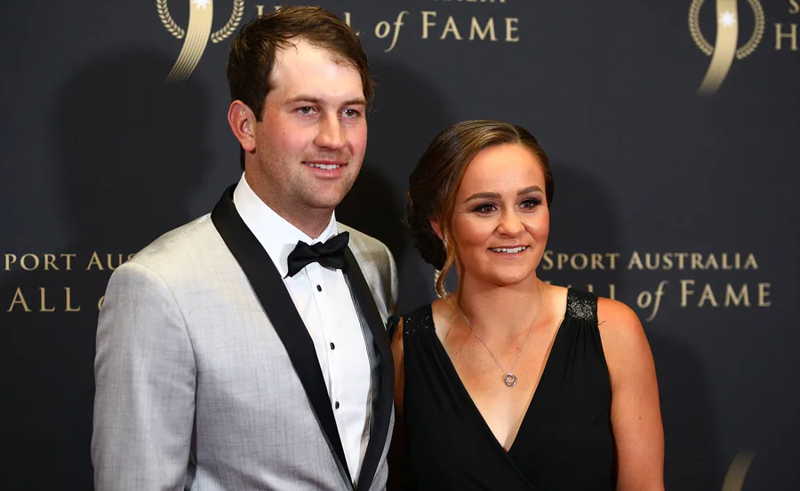A couple posing at the Sport Australia Hall of Fame event; the man is in a tuxedo and the woman in a black dress.
