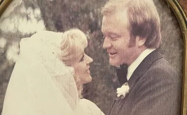A black and white photo of a bride and groom gazing at each other on their wedding day.