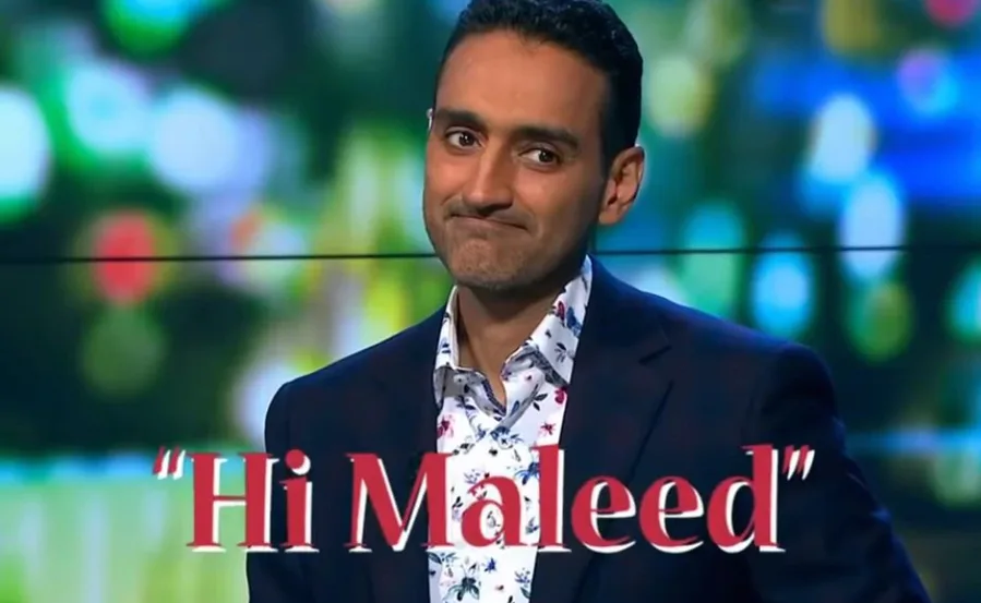 Man in suit with floral shirt, text overlay "Hi Maleed," blurred colorful background.
