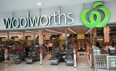 Front entrance of a Woolworths supermarket with checkouts and shoppers inside.