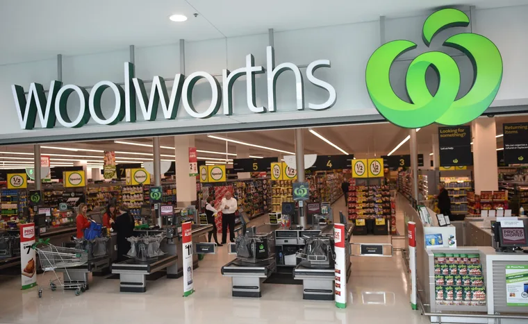 Front entrance of a Woolworths supermarket with checkouts and shoppers inside.
