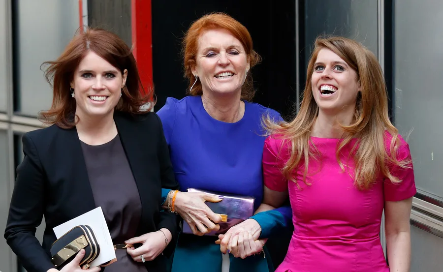 Three women smiling, arm-in-arm, wearing colorful outfits, walking outdoors.