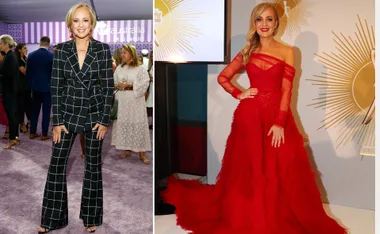 Woman in a black plaid suit on left, and in a red gown on right, smiling at event with people in background.