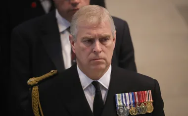 A man in military attire with medals on his chest, looking serious at a public event.