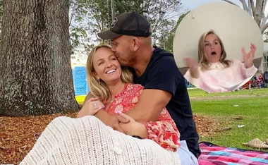 Couple embracing under a tree with a zoomed-in inset of a surprised woman in pink.