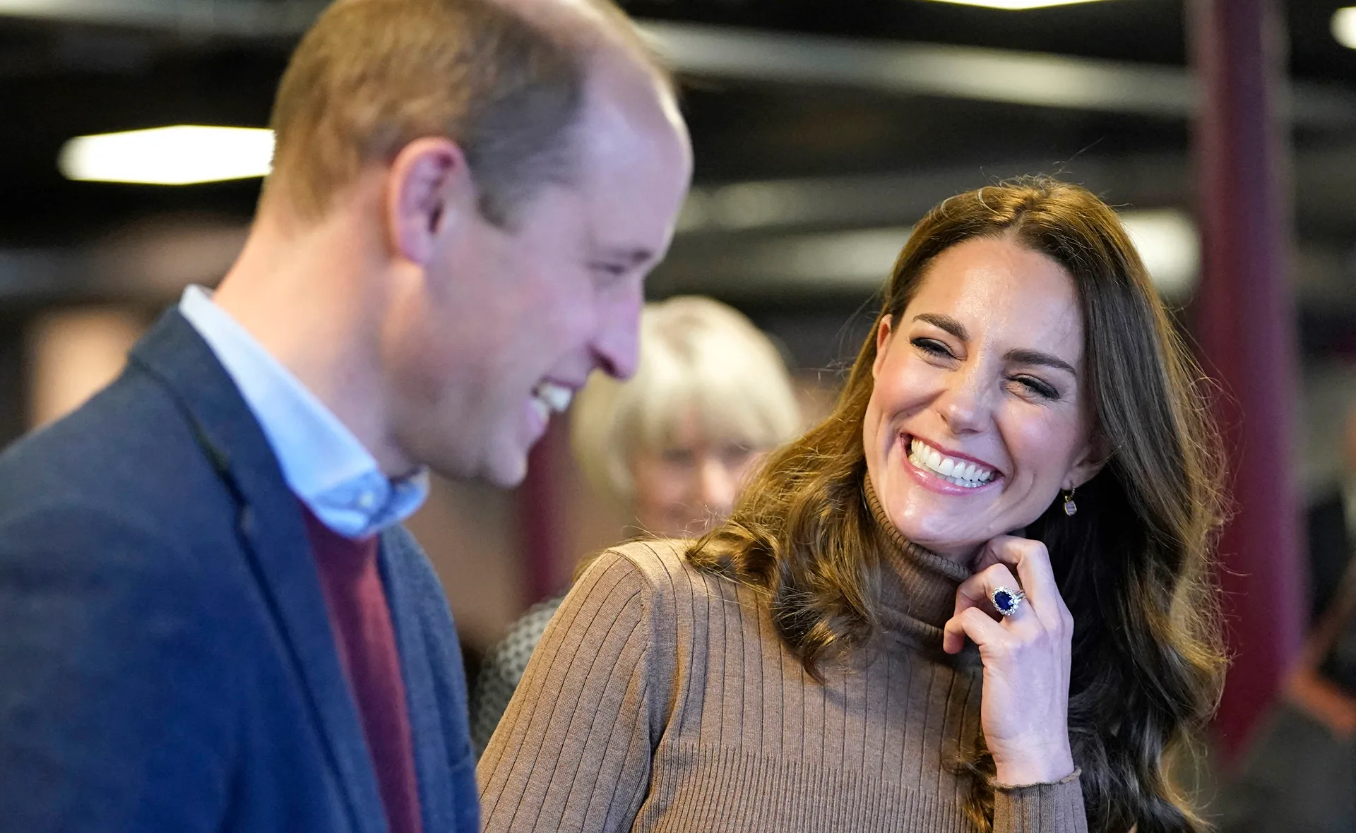 Couple smiling and engaged in conversation at an indoor event.