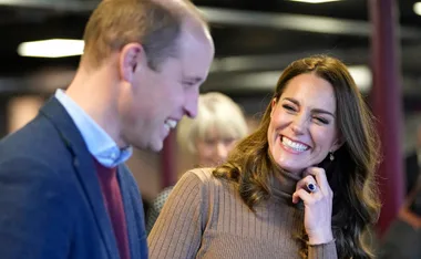 Couple smiling and engaged in conversation at an indoor event.