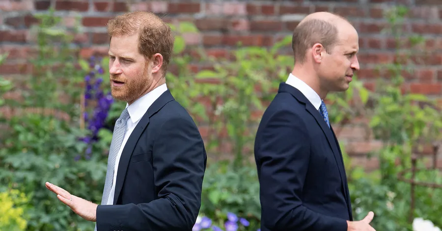 Two men in suits stand back-to-back outdoors with expressions of contemplation.