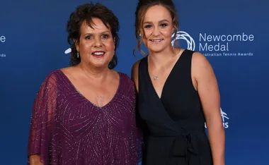 Two women smiling, standing together at the Newcombe Medal Australian Tennis Awards, blue background.
