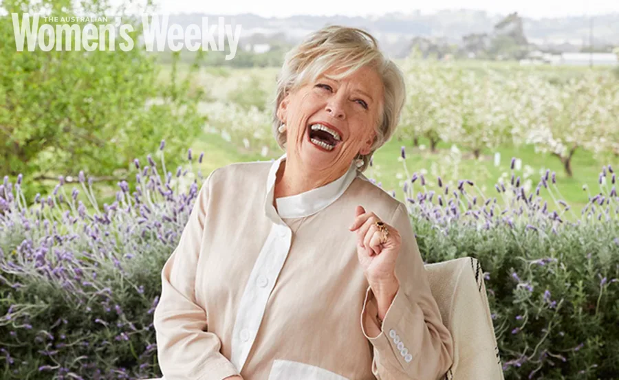 Elderly woman joyfully laughing in a garden setting with lavender and greenery; "Women's Weekly" text in corner.