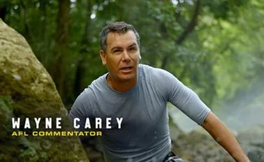 Wayne Carey, AFL commentator, outdoors in a forest, wearing a grey shirt.