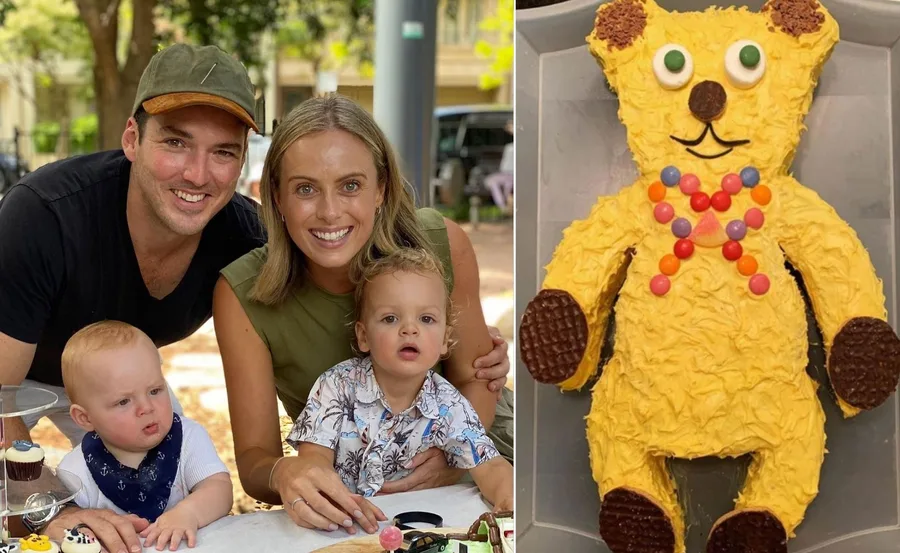 Family celebrating with a yellow bear-shaped birthday cake decorated with colorful candies and chocolate wheels.