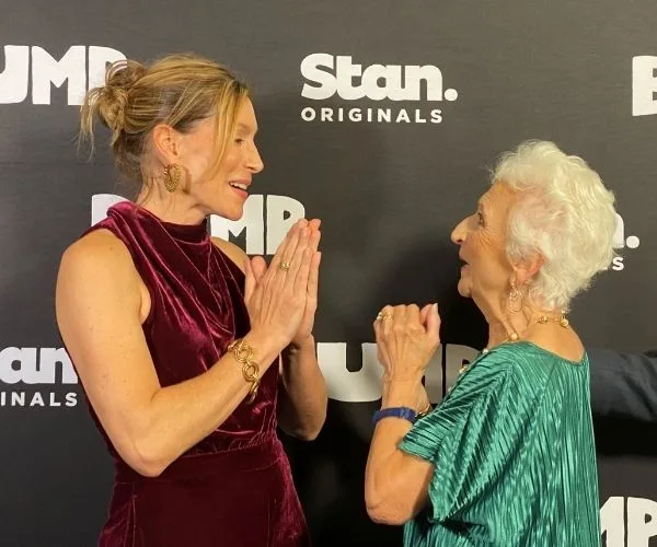 Two women conversing at the "Bump" premiere event, a Stan Originals series backdrop is visible.