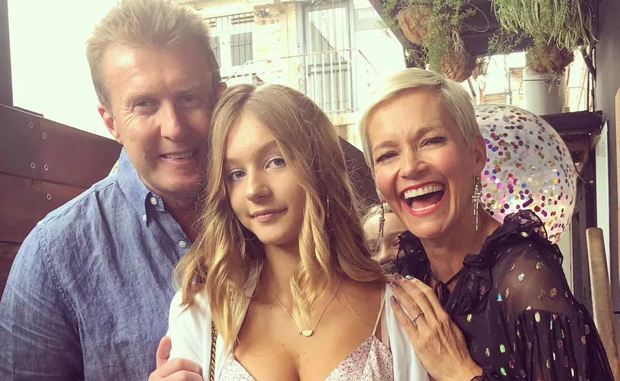A family smiling together, with a confetti-filled balloon in the background.